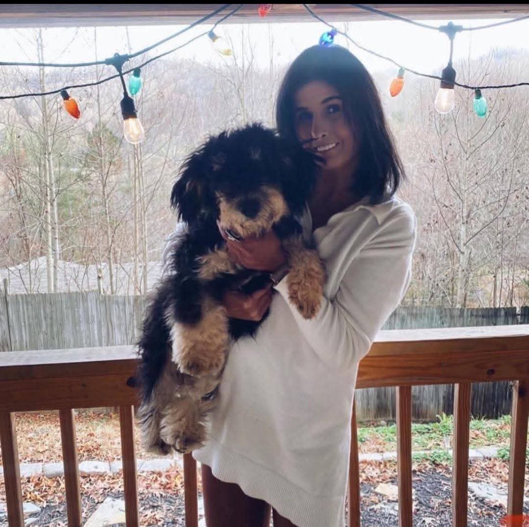 Pawsitive Care pet sitter cuddling a happy pup on a mountain porch